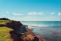 Červené útesy blízko East Point Lighthouse na ostrově Prince Edwarda