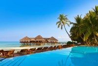 Bazén s volnými lehátky a vodní bungalovy v luxusních resortech na atolu Jižní Ari, Maledivy
