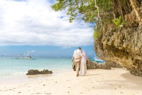 Zamilovaná dvojice procházející se po pláží na Maledivách