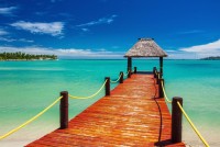 Průzračné moře a dřevěné mole vedoucí k luxusní vile, Maledivy