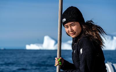 Grónská průvodkyně během plavby po Ilulissat Icefjord loví led pro chlazení nápojů... | Henrik Møller Nielsen - Visit Greenland