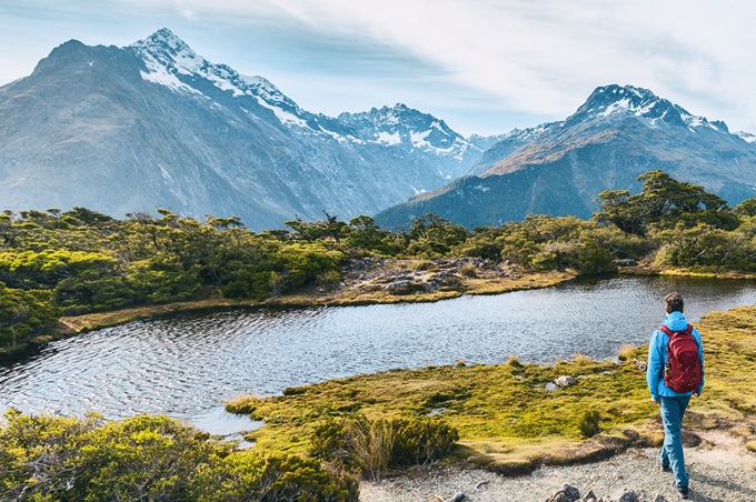 Turista na horské stezce v národním parku Fiordland na Novém Zélandu