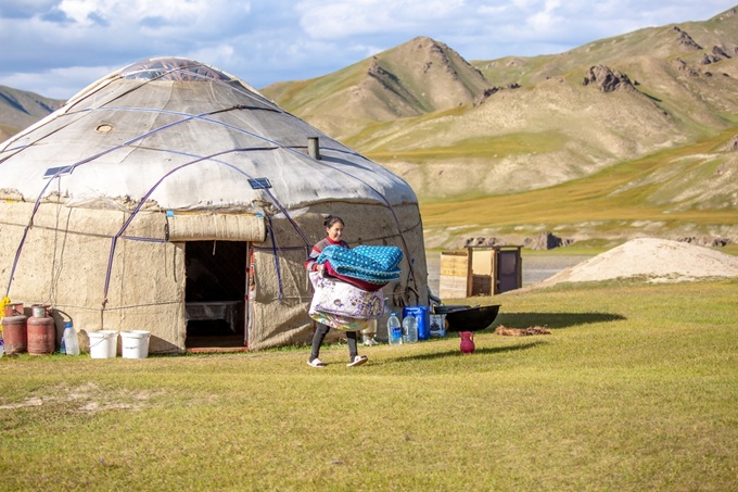 Nomádská jurta v mongolské stepi s horskou krajinou v pozadí
