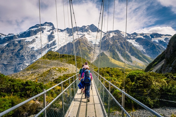 Turisté na visutém mostě v národním parku Aoraki / Mount Cook